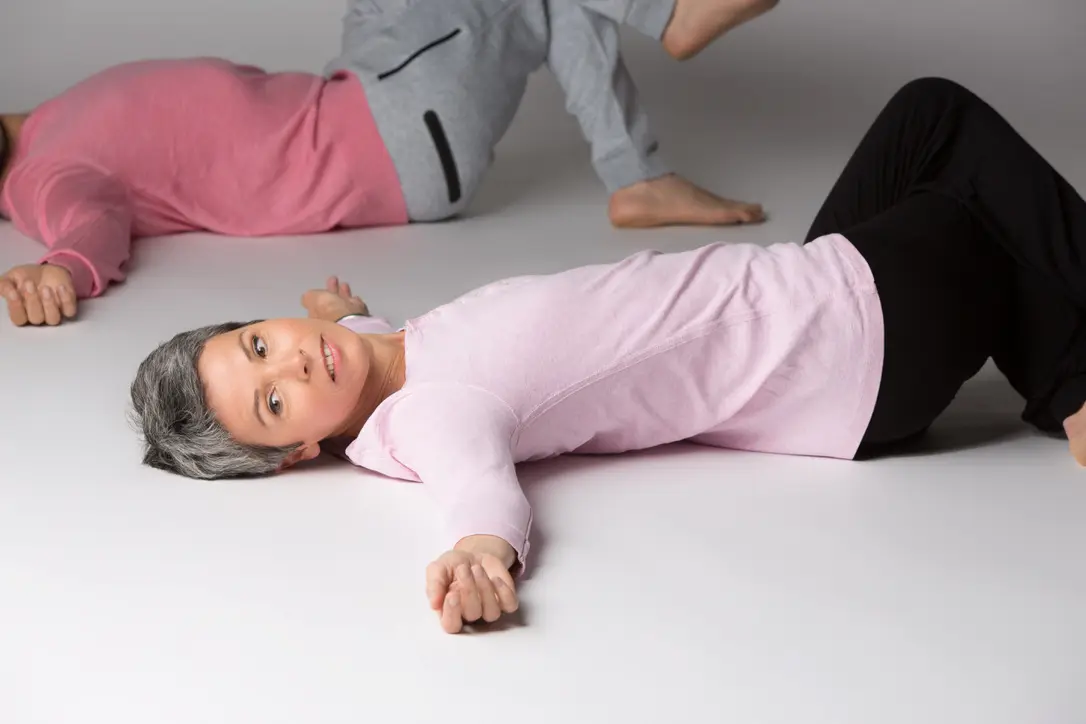 Deux femmes allongées au sol pendant un atelier Mouvement Cool