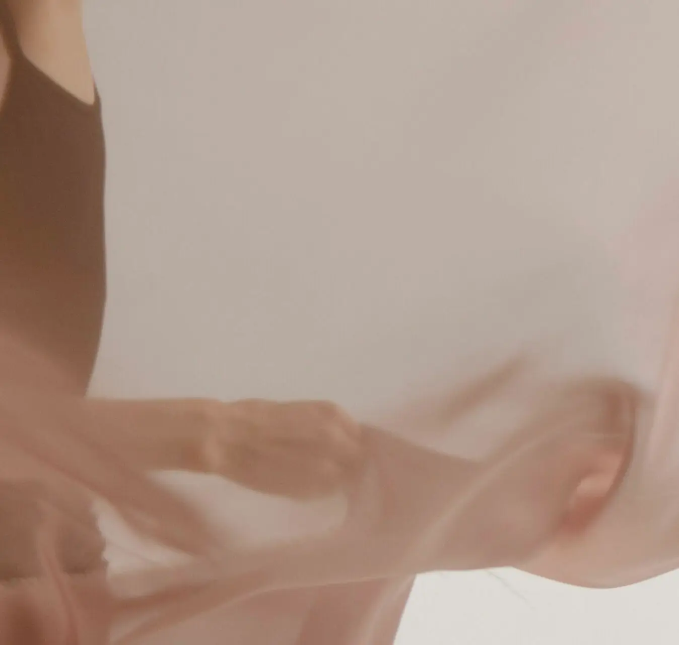 Mains et voile rose clair en mouvement